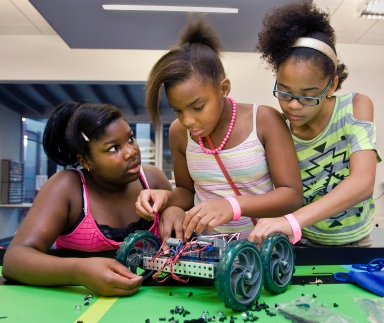 Destnee Walton, 12, from left, Martayllia Copes, 10, and Jordan Miller, 11, all of Kansas City, assemble a robot, July 20, at Science City in Kansas City's Union Station. Courtesy of mctcampus.com